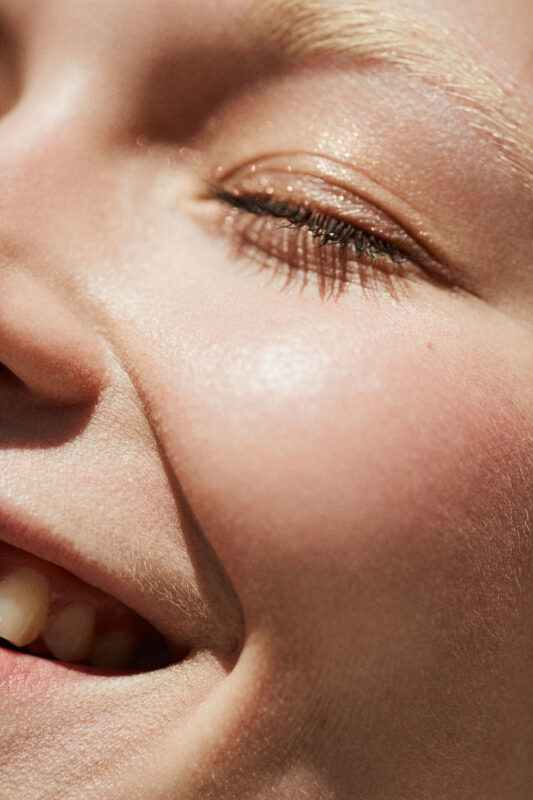 Lachendes sehr nahes Foto von einer jungen Frau.