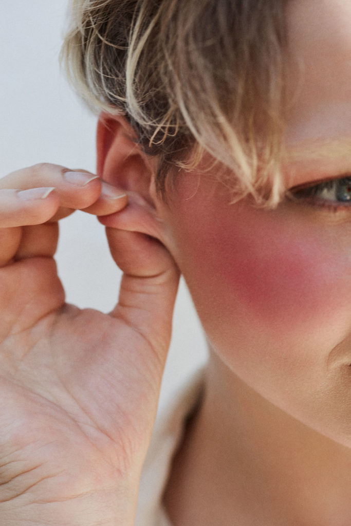 beautyfoto einer jungen blonden frau mit pinkem rouge.