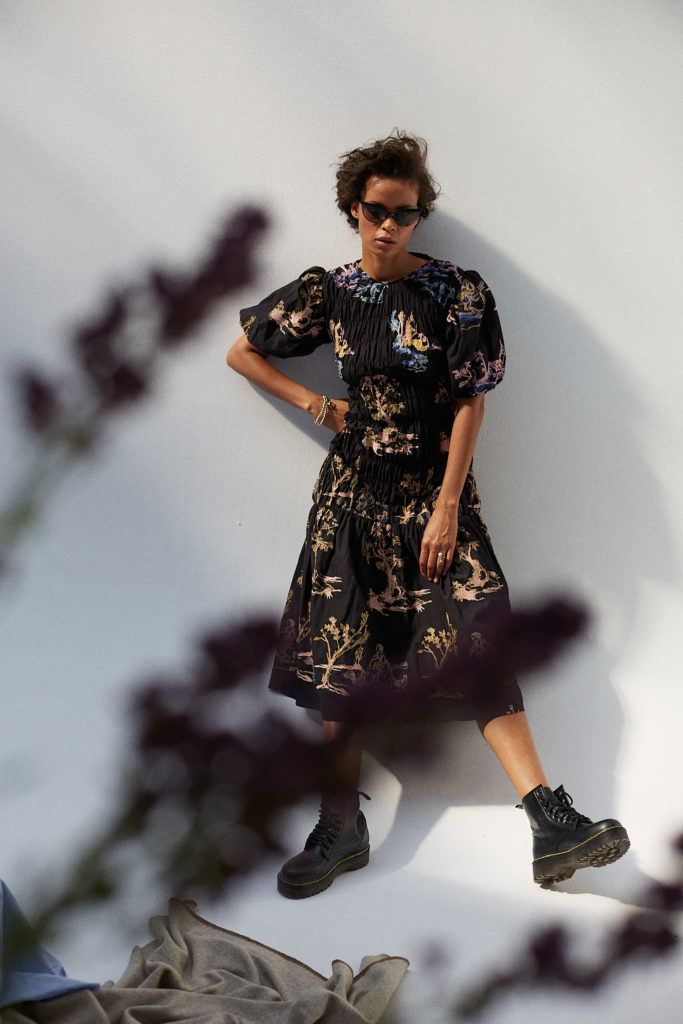 Schwarzes weibliches Model in Sommerkleid mit Sonnenbrille im Studio. Sehr cool fotografiert von Verena Vötter, München.