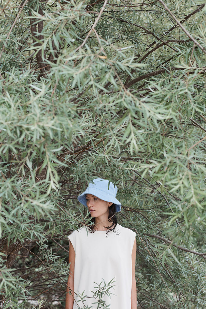 model steht unter baum, baum nimmt das gesamte bild ein, model ist unterhalb der brust abgeschnitten