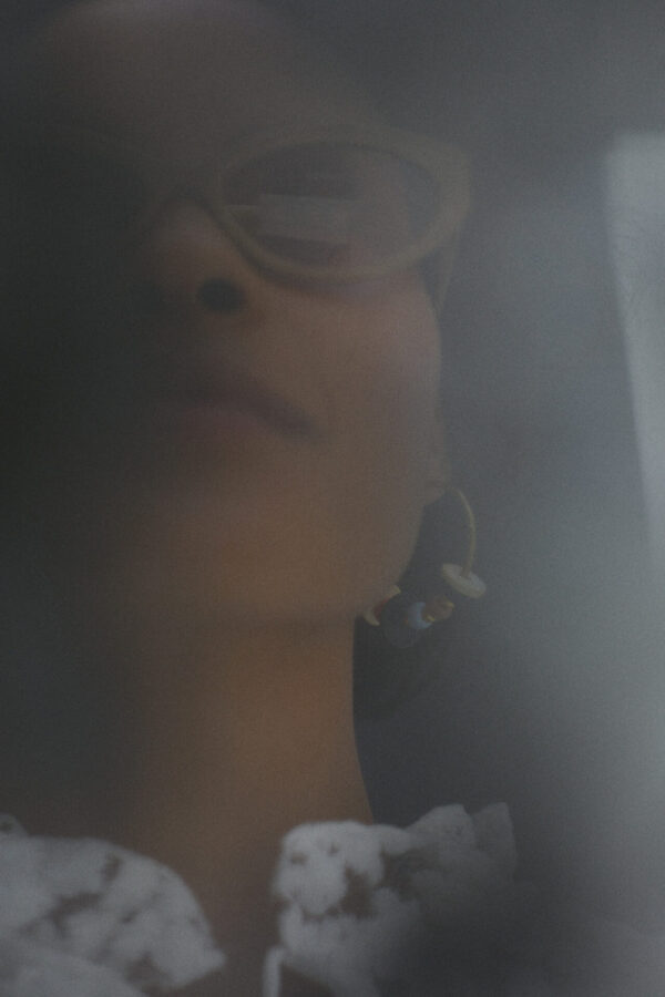 Unscharfes Bild von einem Model mit Sonnenbrille im Studio. Sehr lässig und modern.