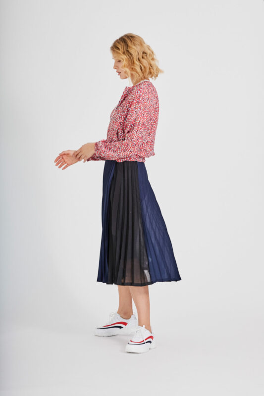 weibliches Model im Fotostudio mit Rock und Jacke im Marinelook.