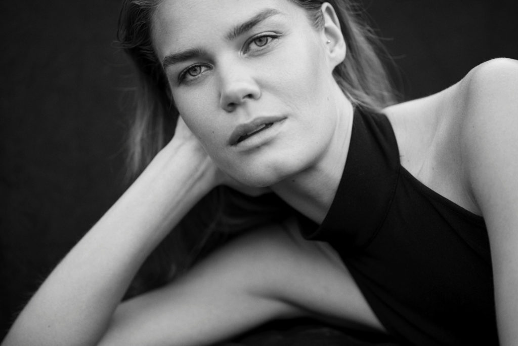 schwarz weiß Bild von Model, dass in die Kamera schaut. Sehr schick und elegent