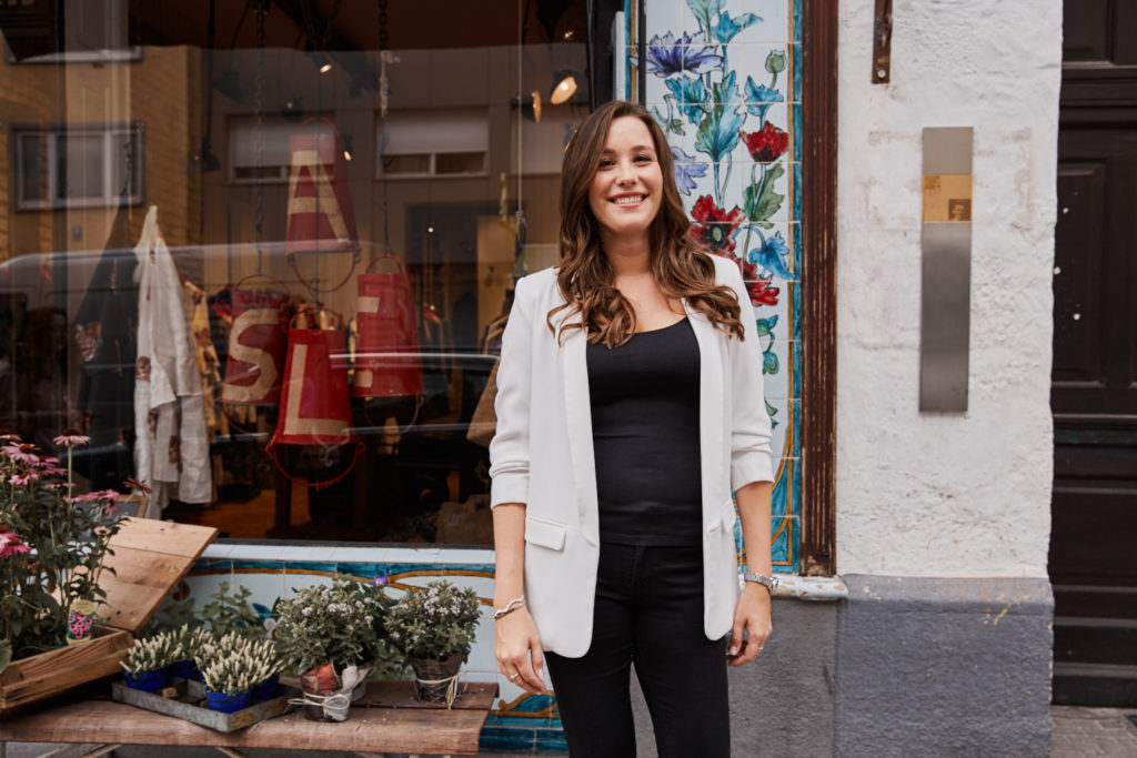 junge-frau-steht-vor-schaufenster-lacht