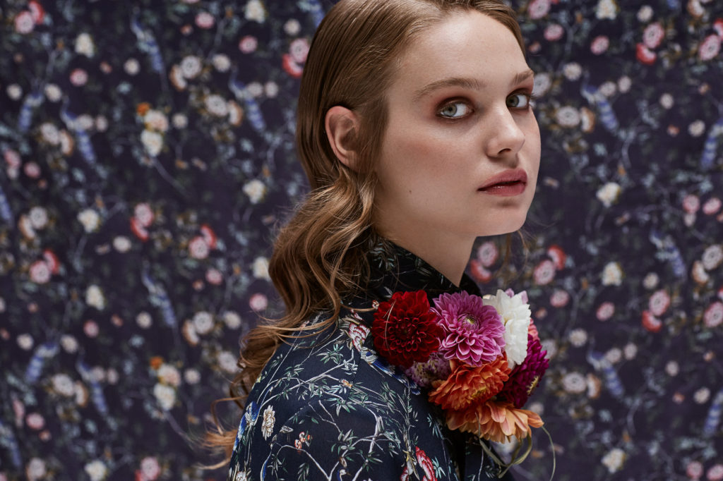 model-schaut-in-die-kamera-hintergrund-selber-stoff-wie-oberteil