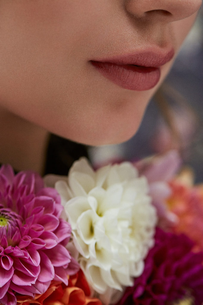 anschnitt-von-model-haut-mund-und-blumen-zu-sehen