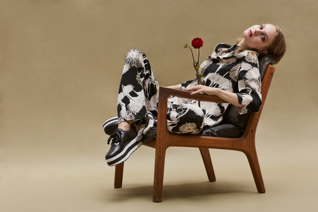 model-sitzt-in-stuhl-mit-zurueckgelegten-kopf