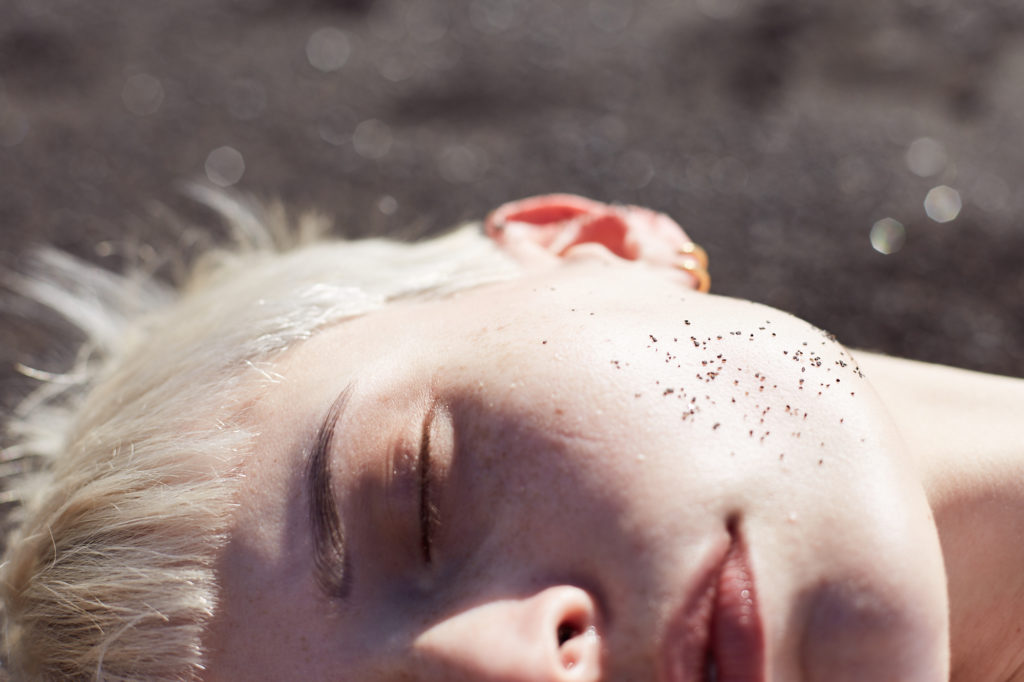clsoe-up-von-gesicht-mit-schwarzem-sand-auf-backe