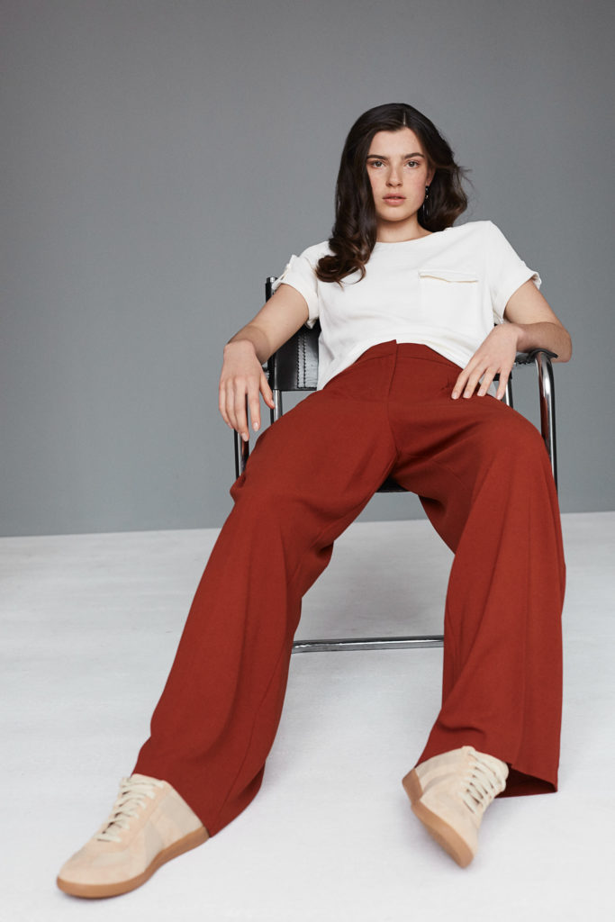 model-im-studio-grauer-hintergrund-liegt-tief-im-stuhl