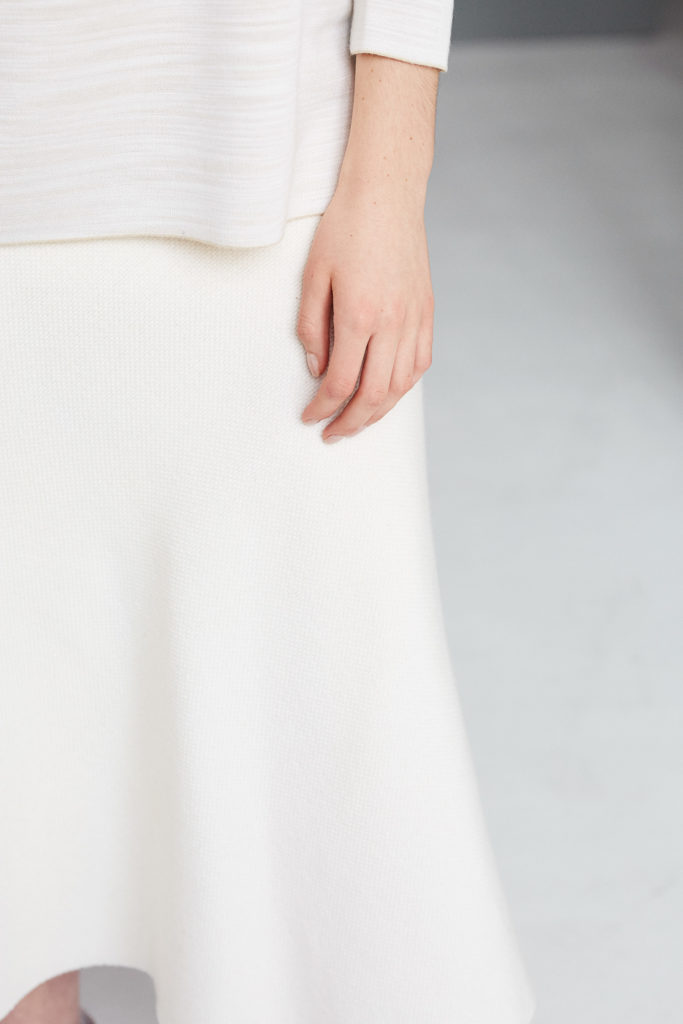 hand-von-model-vor-weißem-rock-weißer-boden