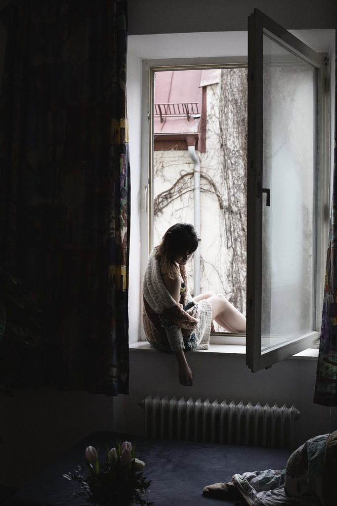 frau in küche, sitzt auf der fensterbakn, sehr stimmungsvoll