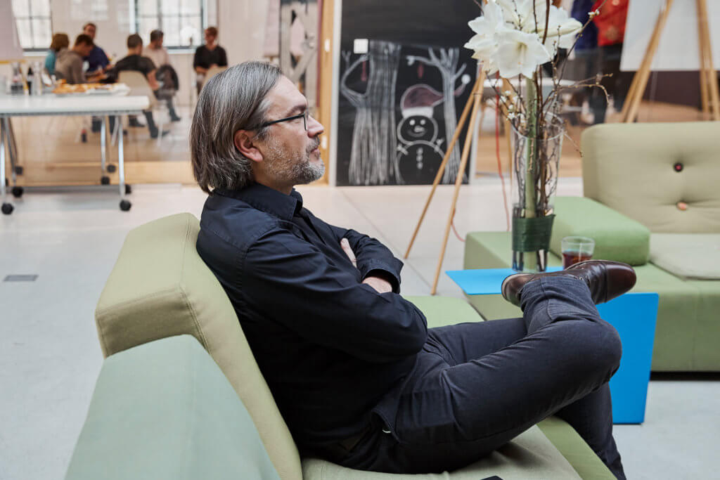 mann der auf couch sitzt, von der seite