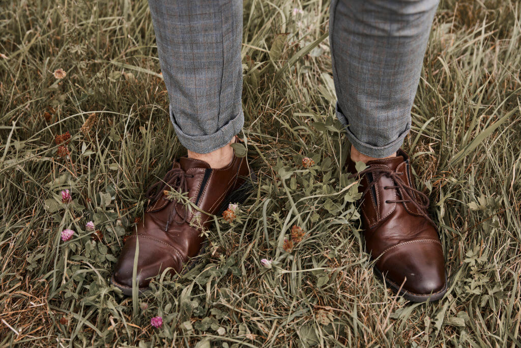 Bräutigäm im Gras stehen, schicke Schuhe und Hose zu sehen, oldscool