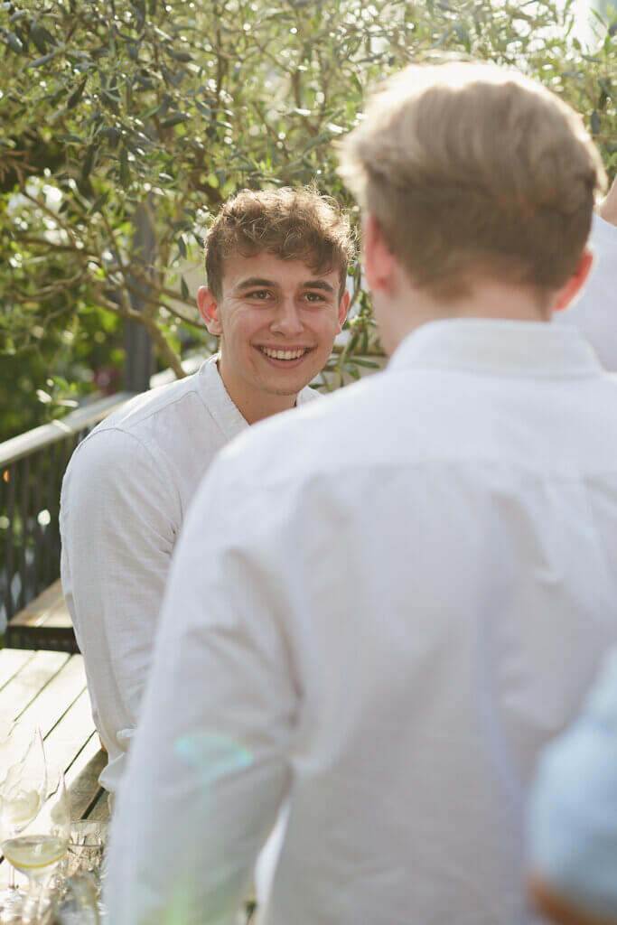 zwei männer unterhalten sich bei sommerfest auf terrasse