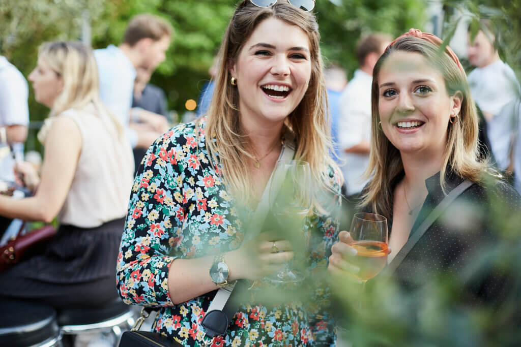 Zwei junge Frauen lachen in die Kamera.