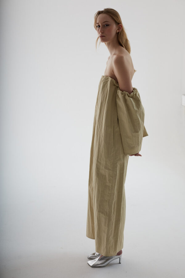 Schlankes Model im Fotostudio mit langem Kleid. Sehr nüchtern. 