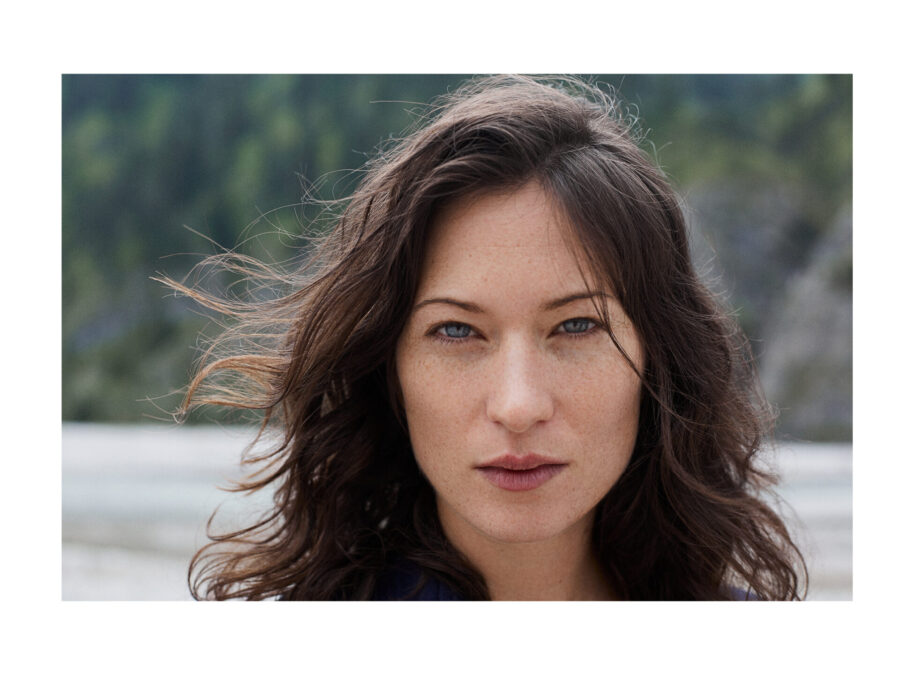 Ein portrait einer dunkelhaarigen Frau, recht nah fotografiert. Sehr hübsch und reduziert.