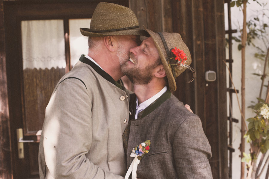 Ein schwules Paar in Tracht, dass sich umarmt. Fotografiert bei ihrer Hochzeit von Verena Vötter.