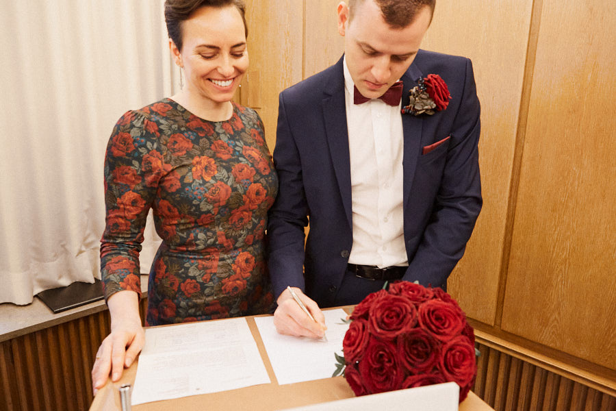 Brautpaar unterschreibt im Standesamt.