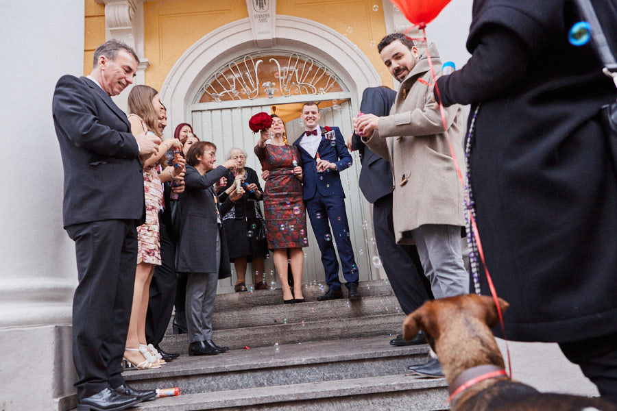 Eine Hochzeitsgesellschaft vor dem Standesamt Mandlstraße in München.