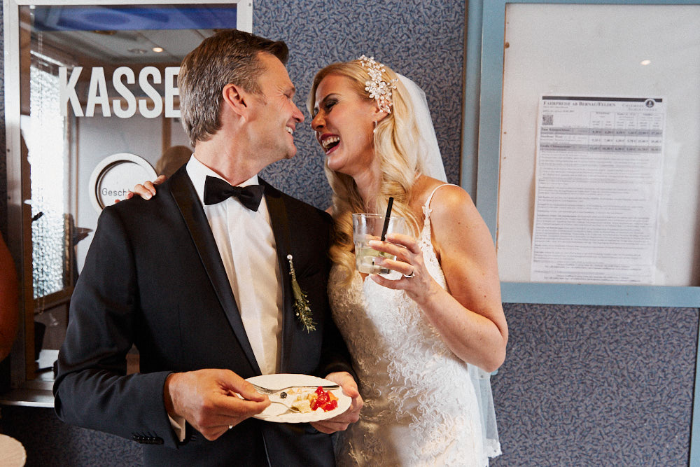 Braut und Bräutigam vor dem Kassenhäuschen auf einem Schiff am Chiemsee.