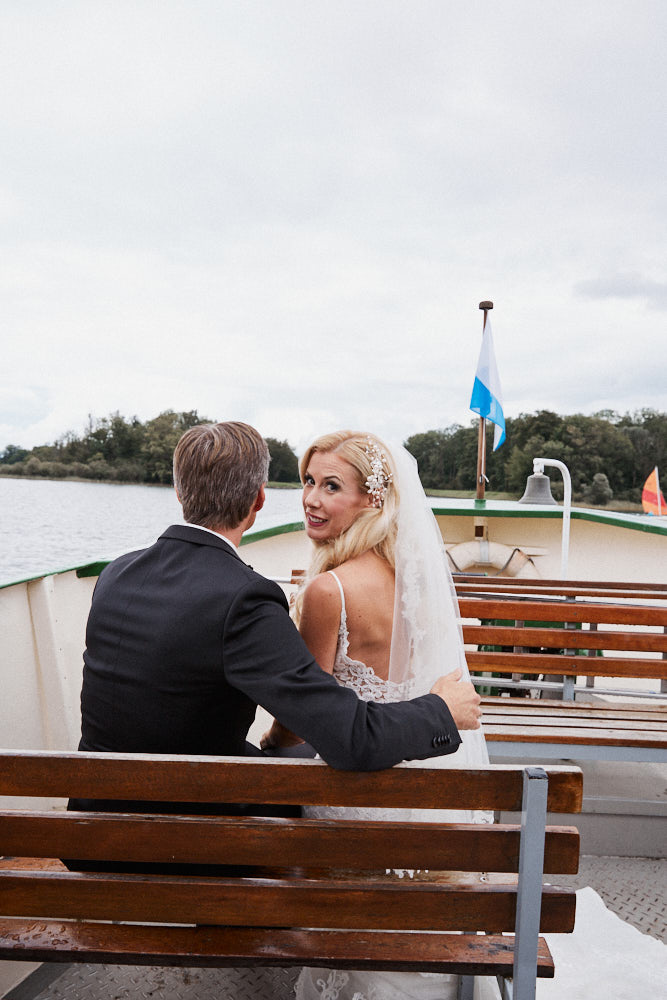 Braut und Bräutigam sitzen auf einem Schiff am Chiemsee.