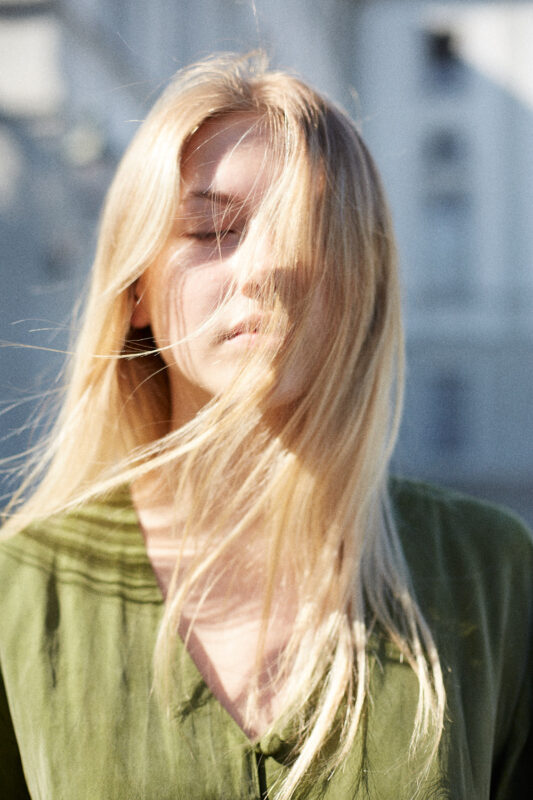 blonde junge frau mit verwehten Haaren.